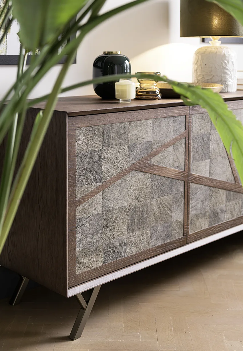 Dettaglio credenza di design in legno scuro con ante in pietra naturale e oggetti decorativi