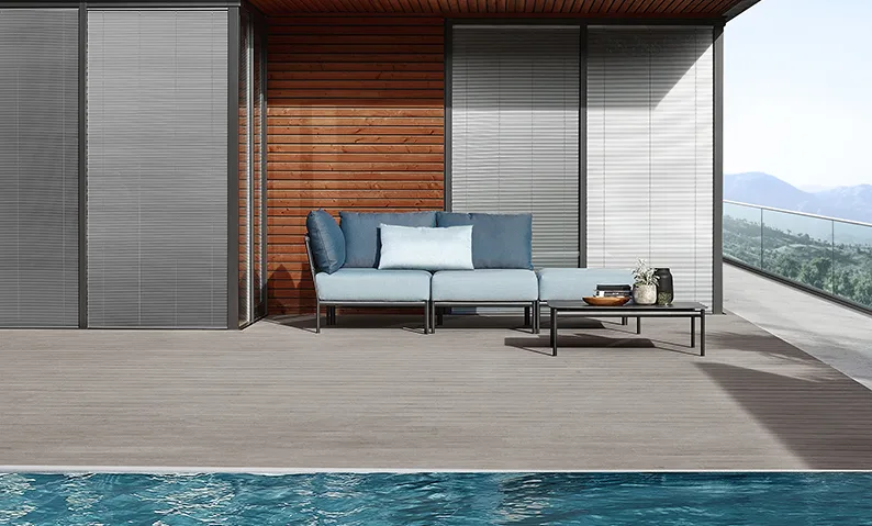 Terrazza con piscina, divano modulare con cuscini azzurri e struttura in metallo, architettura contemporanea con vista montagna